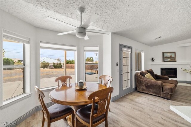 dining room with ceiling fan, a textured ceiling, and light hardwood / wood-style floors