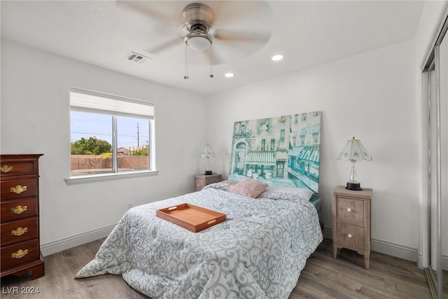 bedroom with a closet, hardwood / wood-style floors, and ceiling fan