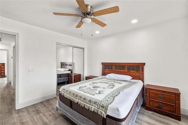 bedroom featuring ceiling fan, light hardwood / wood-style floors, and a closet