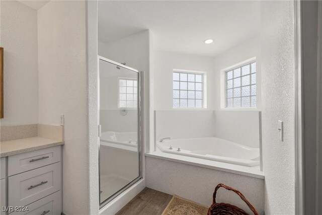 bathroom featuring hardwood / wood-style flooring, vanity, and independent shower and bath