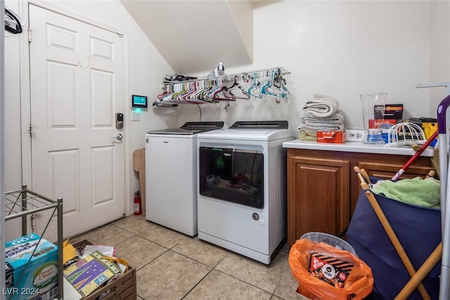 washroom with cabinets, light tile patterned flooring, and washer and clothes dryer