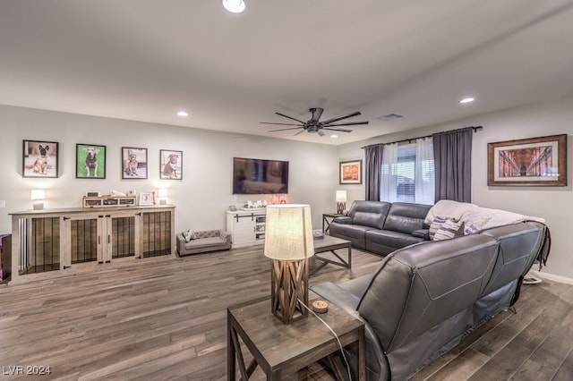 living room featuring ceiling fan and dark hardwood / wood-style floors