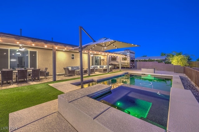 pool at night featuring an outdoor hangout area and a patio