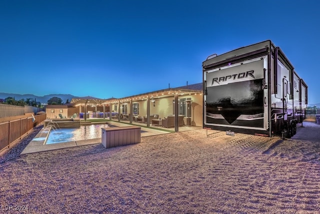 back of property with pool water feature, a fenced in pool, and a patio