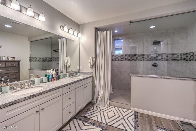 bathroom featuring double sink vanity, walk in shower, and hardwood / wood-style floors