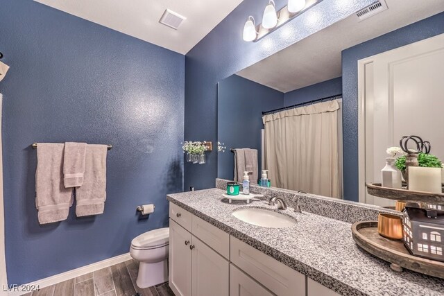 bathroom featuring hardwood / wood-style flooring, vanity, and toilet