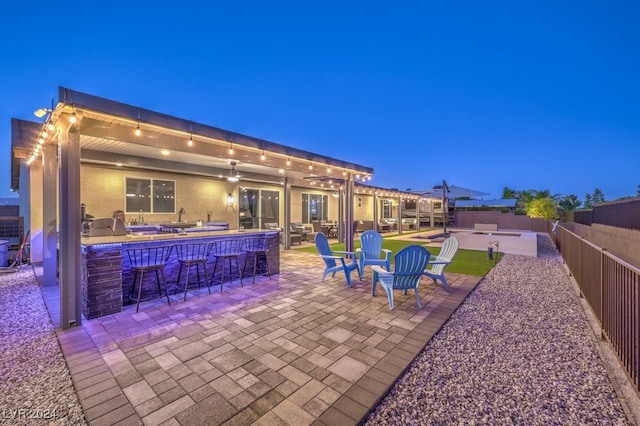 patio at night featuring exterior bar