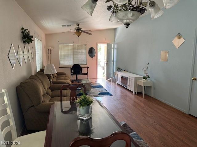 living room with lofted ceiling, dark wood-type flooring, and ceiling fan