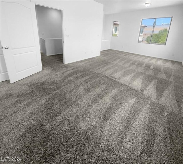 spare room with dark colored carpet