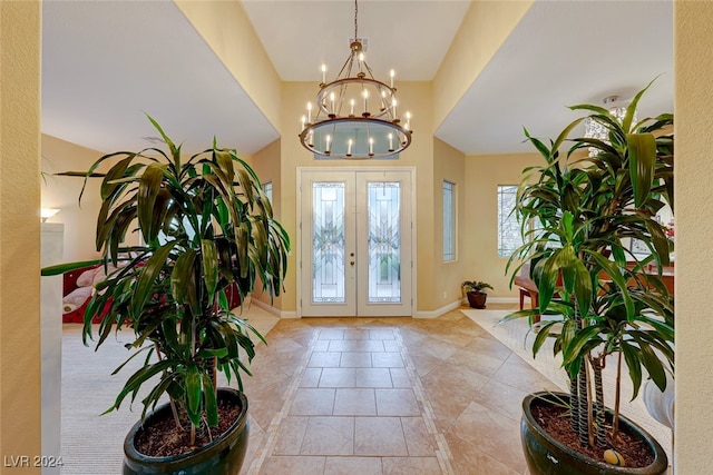 entryway featuring light tile patterned floors, french doors, and an inviting chandelier