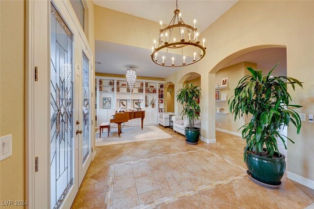 tiled entrance foyer with a chandelier