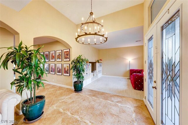 carpeted entrance foyer with a chandelier