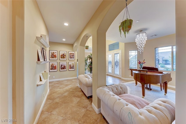 living room with a notable chandelier, french doors, and light tile patterned floors