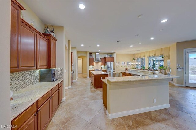 kitchen with stainless steel fridge with ice dispenser, a center island, light tile patterned floors, decorative backsplash, and wall chimney exhaust hood