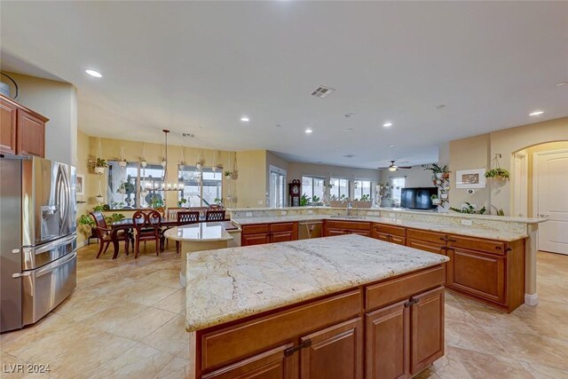 kitchen featuring appliances with stainless steel finishes, kitchen peninsula, a kitchen island, and ceiling fan