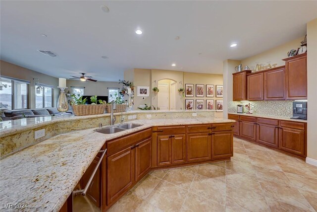 kitchen with ceiling fan, sink, light stone countertops, and light tile patterned floors