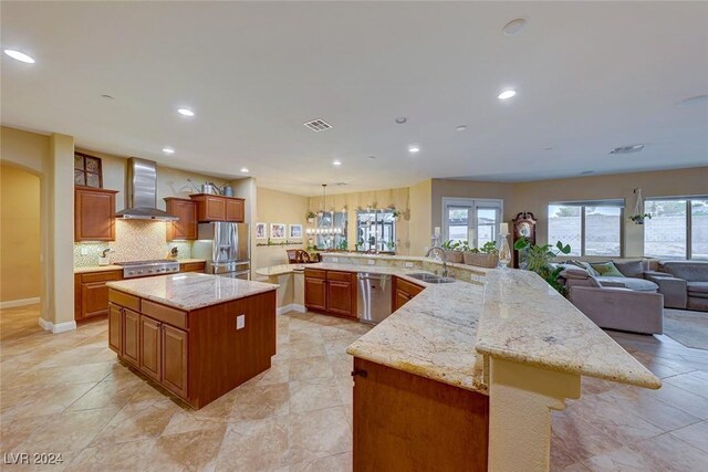 kitchen with sink, light tile patterned flooring, a spacious island, light stone counters, and wall chimney exhaust hood