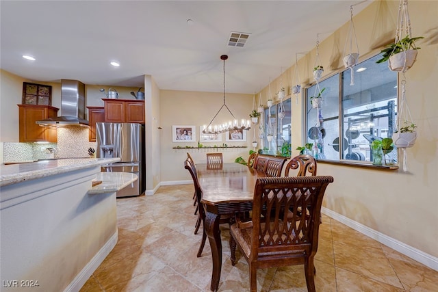 tiled dining room featuring an inviting chandelier