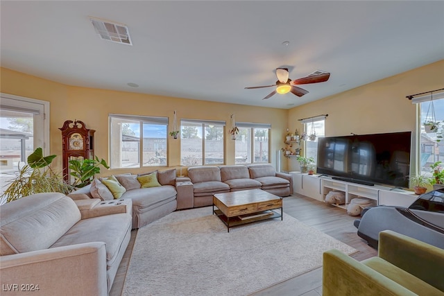 living room featuring ceiling fan and light hardwood / wood-style floors