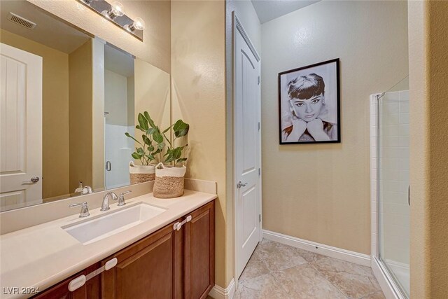 bathroom with a shower with door, tile patterned floors, and vanity