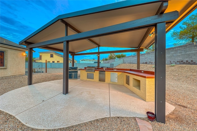 view of patio with an outdoor kitchen and a grill