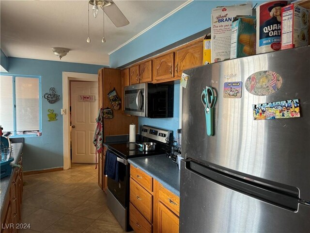 kitchen with ceiling fan, light tile patterned flooring, and stainless steel appliances