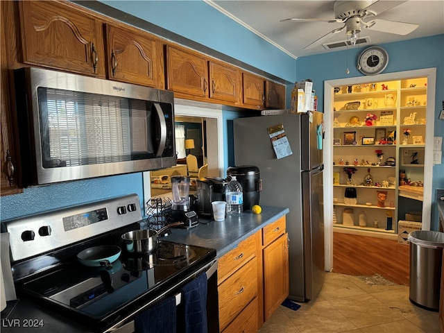 kitchen featuring ceiling fan, light tile patterned floors, stainless steel appliances, and crown molding