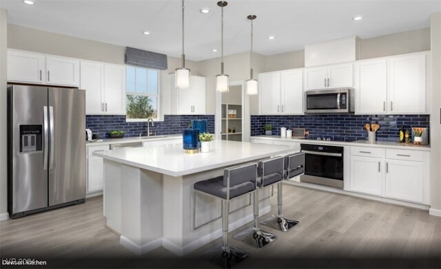 kitchen featuring light wood-type flooring, backsplash, white cabinetry, black appliances, and decorative light fixtures