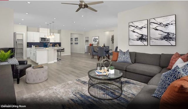 living room with ceiling fan and light wood-type flooring