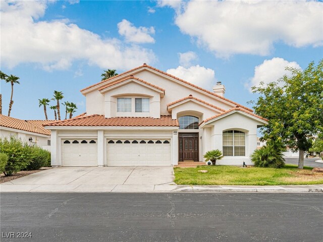 mediterranean / spanish-style house with a garage