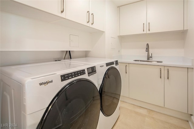 clothes washing area with light tile patterned floors, sink, cabinets, and washer and dryer