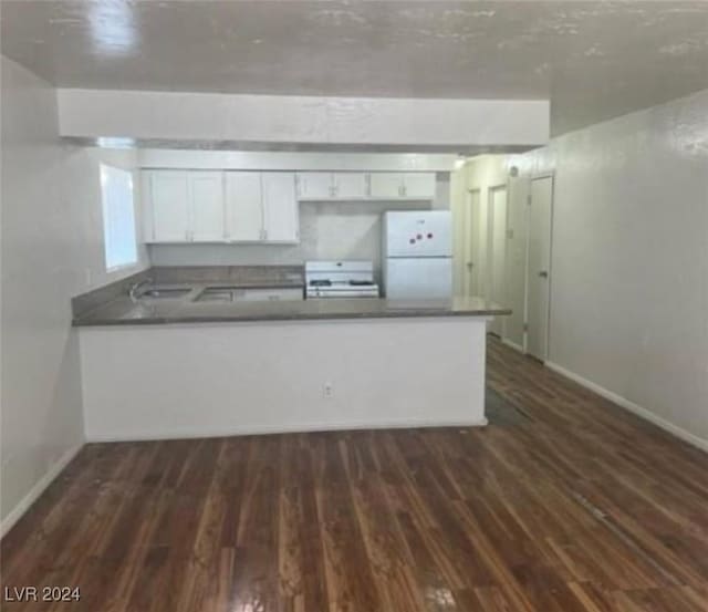 kitchen with dark hardwood / wood-style flooring, white appliances, kitchen peninsula, and white cabinets