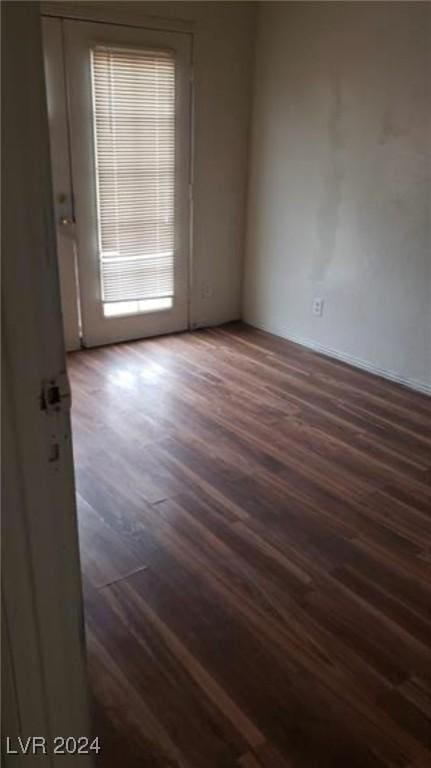 unfurnished room with dark wood-type flooring