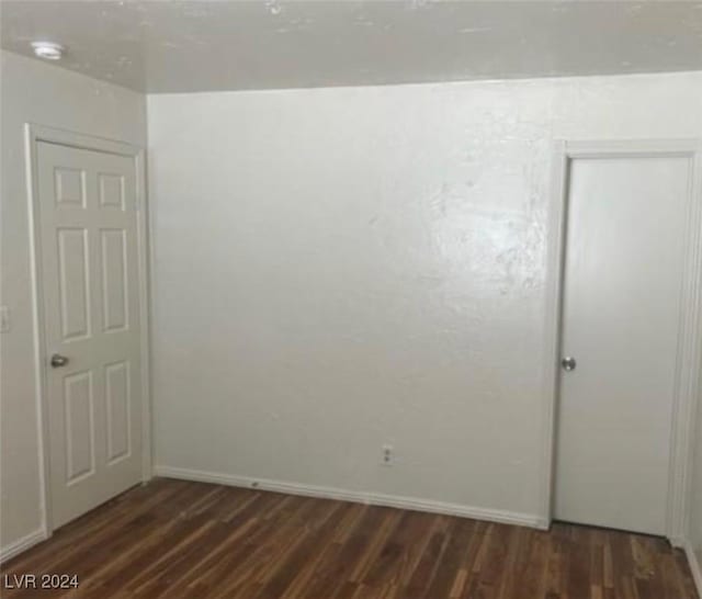 unfurnished room featuring dark wood-type flooring