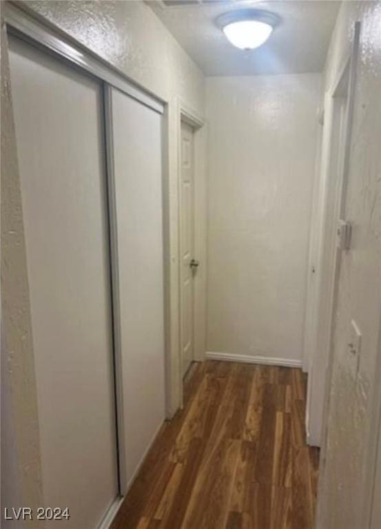 hallway with dark hardwood / wood-style flooring