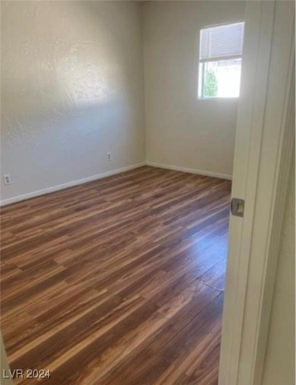 unfurnished room featuring dark wood-type flooring