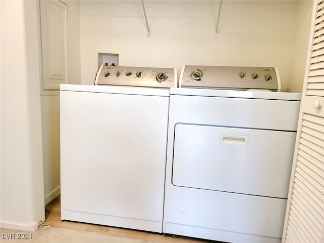 clothes washing area featuring light wood-type flooring and independent washer and dryer