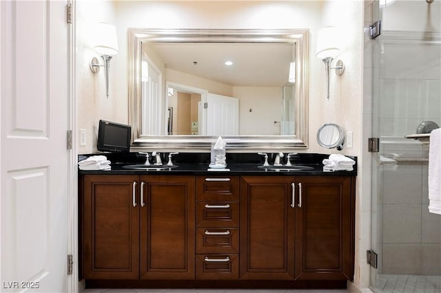 bathroom with a sink, a shower stall, and double vanity