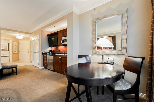 dining space with baseboards and crown molding