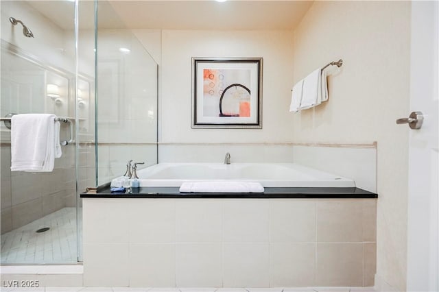 bathroom featuring a stall shower and a bath