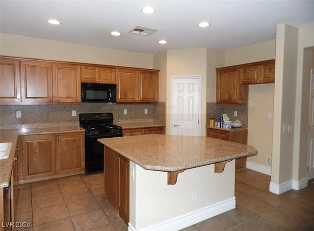 kitchen with tile patterned flooring, black appliances, a center island, and backsplash