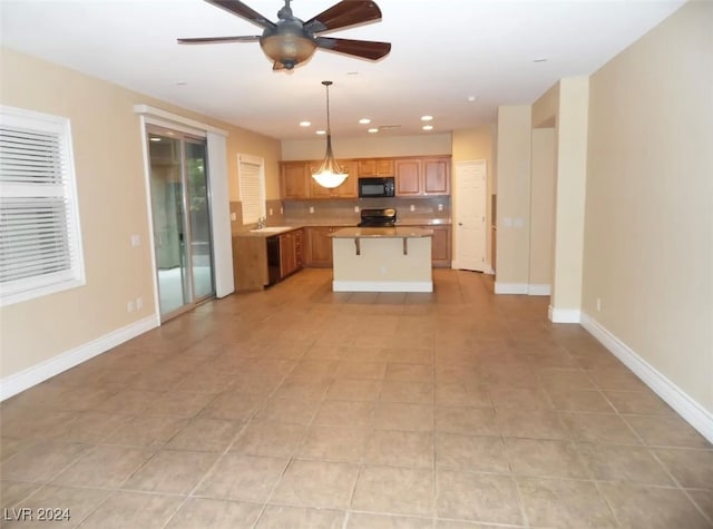 kitchen with ceiling fan, pendant lighting, stove, light tile patterned floors, and a kitchen island