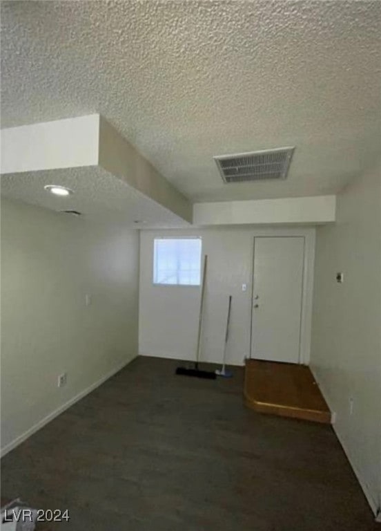 empty room featuring a textured ceiling and carpet flooring