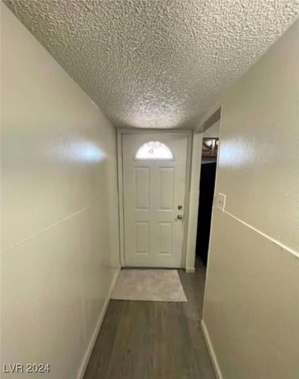 doorway to outside featuring a textured ceiling and hardwood / wood-style floors