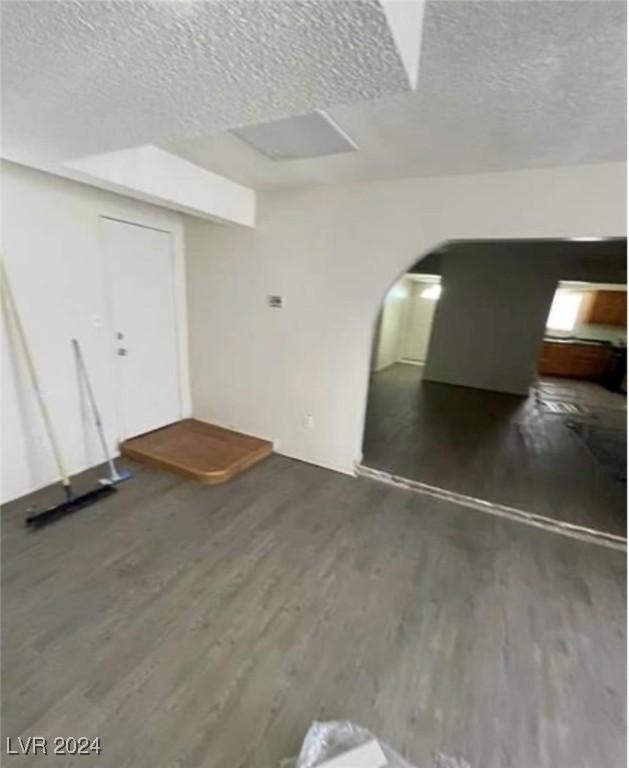 interior space with a textured ceiling and hardwood / wood-style flooring