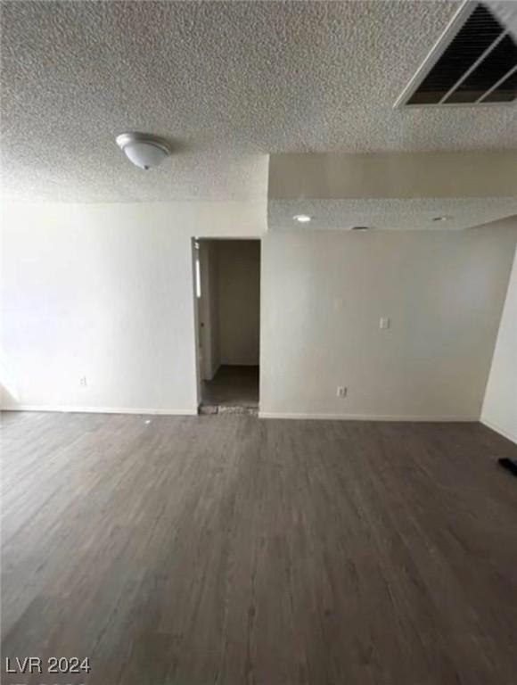 unfurnished room featuring a textured ceiling and hardwood / wood-style floors