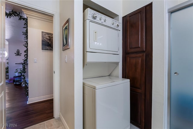 washroom with light hardwood / wood-style flooring and stacked washer / drying machine