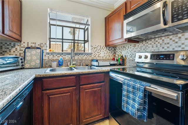 kitchen featuring appliances with stainless steel finishes, sink, crown molding, and decorative backsplash