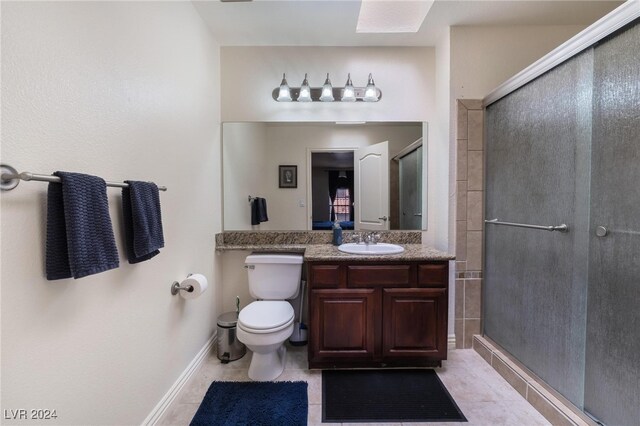 bathroom featuring walk in shower, vanity, toilet, and tile patterned flooring