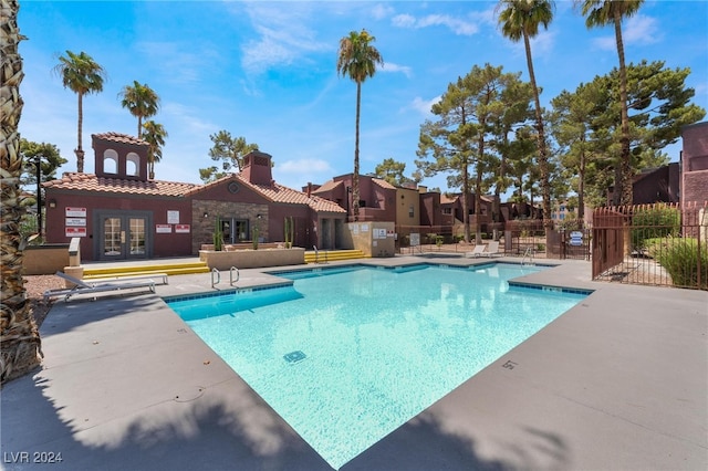 view of swimming pool with french doors and a patio area